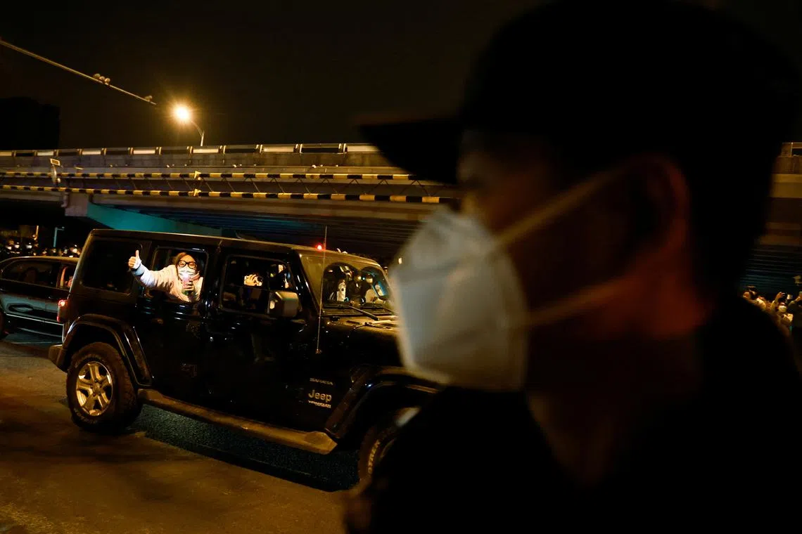 A person gestures from a car as people gather for a vigil and hold white sheets of paper in protest of coronavirus disease restrictions, during a commemoration of the victims of a fire in Urumqi, as outbreaks of the coronavirus disease continue in Beijing, China, Nov 27, 2022. 