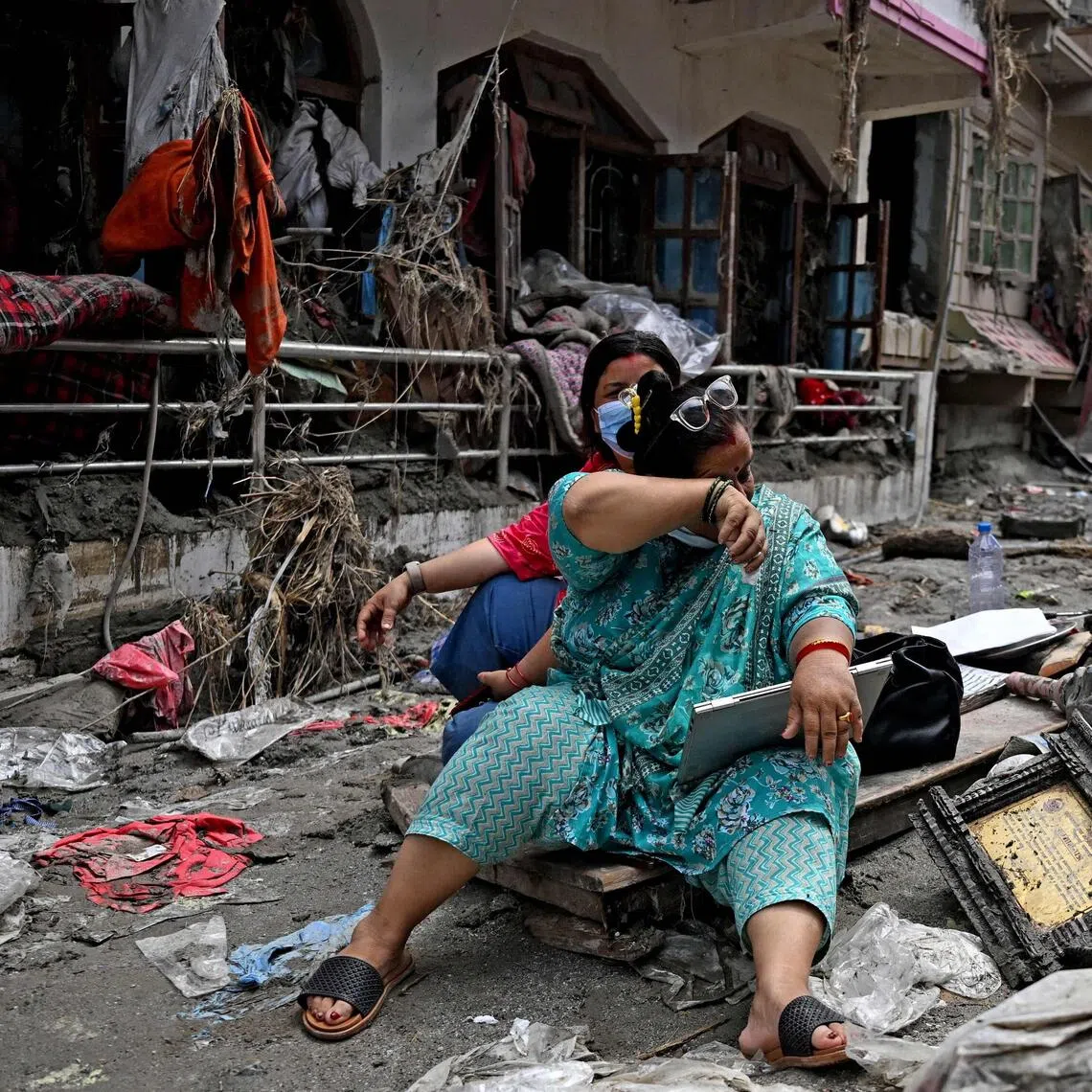 People salvage belongings from their home following flash floods in Nepal’s Nuwakot district.