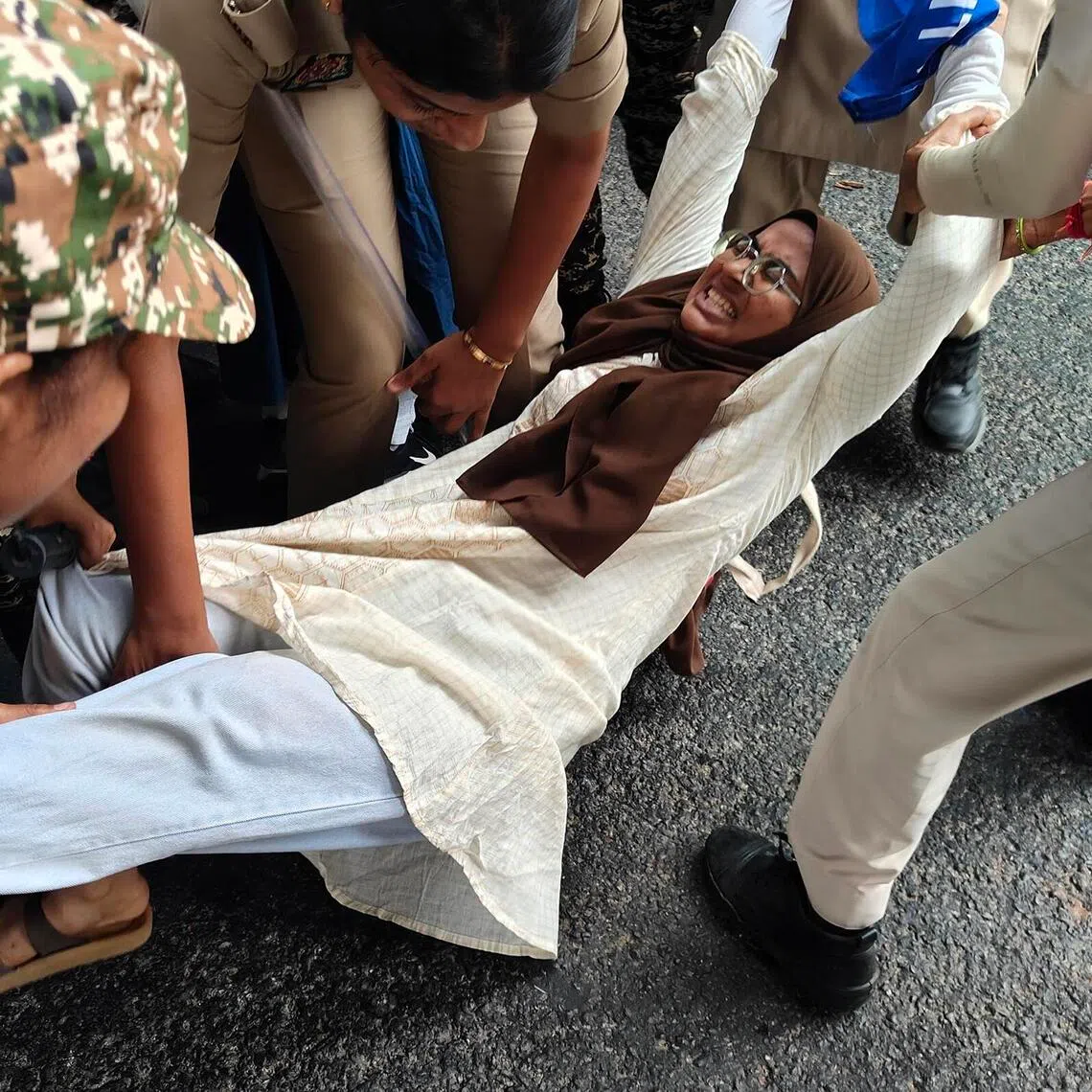 A woman protester being detained by security personnel in New Delhi, India, on Oct 11.