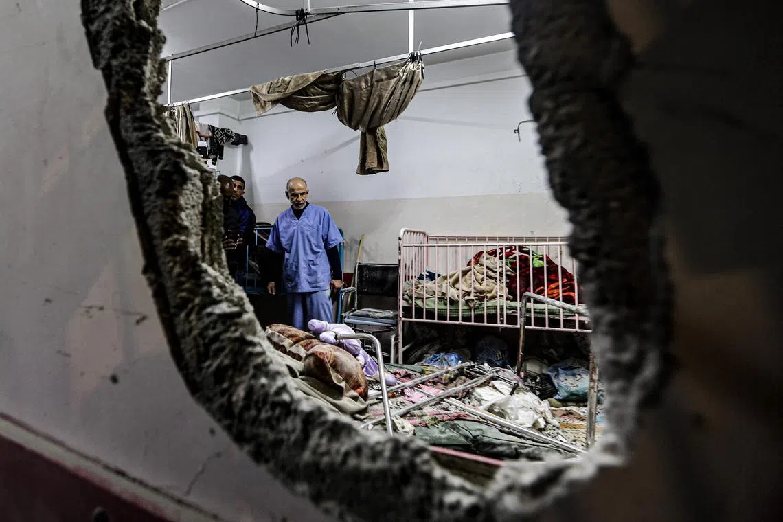 People inspect the damage in a room following Israeli bombardment at Nasser hospital in Khan Yunis in the southern Gaza Strip on Dec 17, 2023.