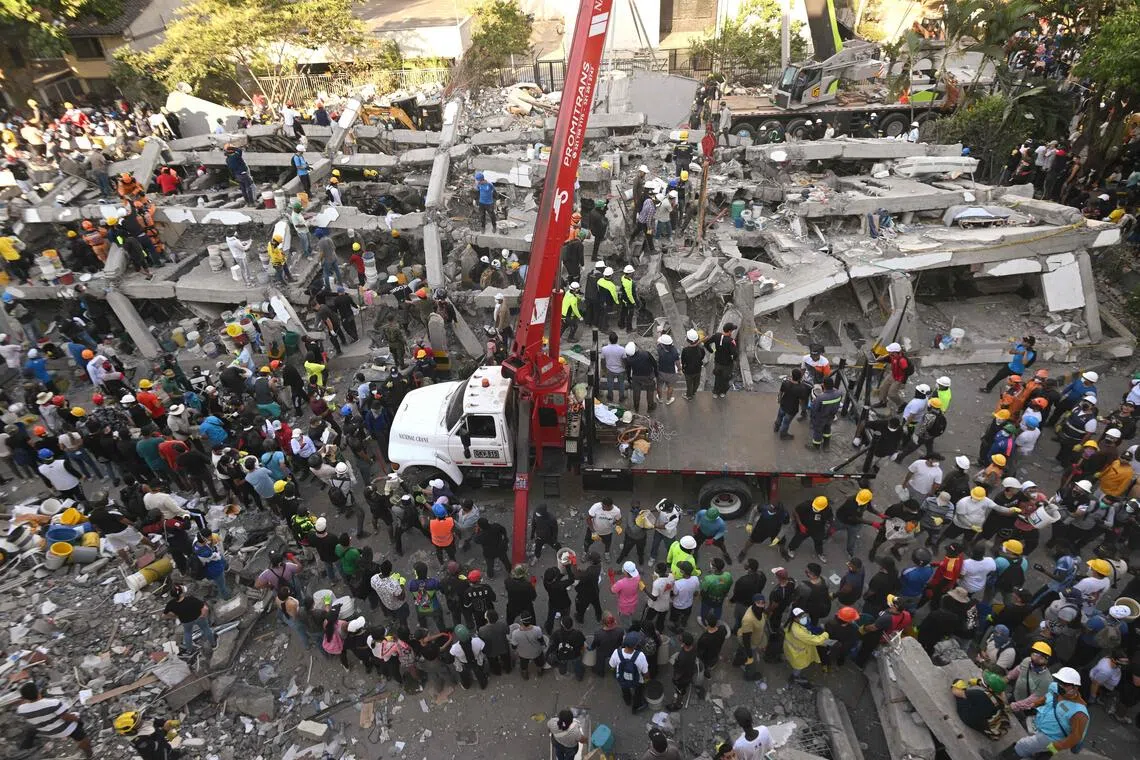 Rescuers and volunteers search for survivors amid the rubble of a collapsed building after an earthquake in Colombia.