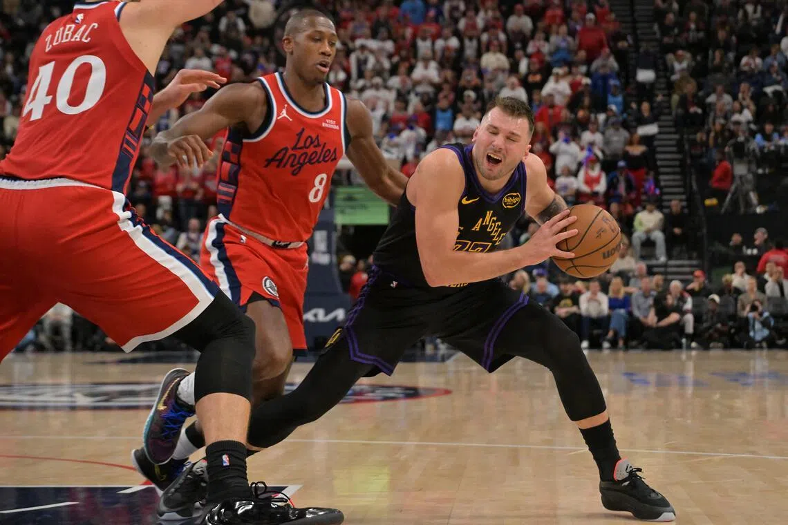 Los Angeles Lakers guard Luka Doncic is defended by Los Angeles Clippers center Ivica Zubac and guard Kris Dunn in the second half at Intuit Dome. 