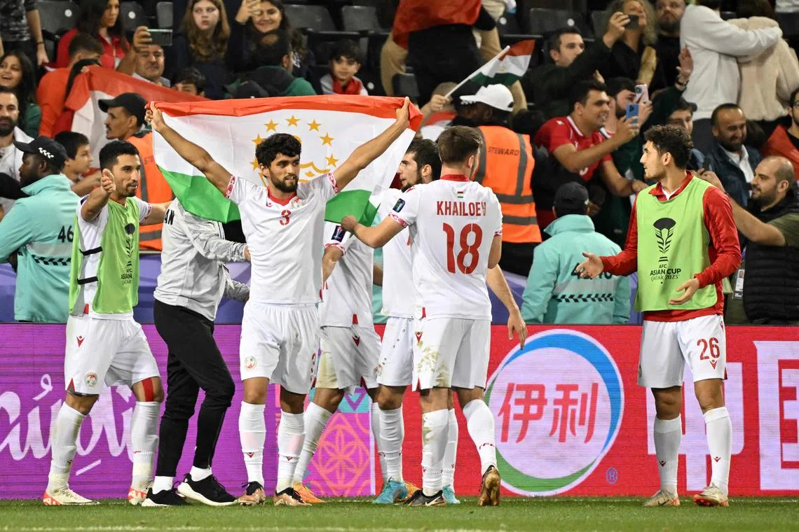 Tajikistan's players celebrate their win after the Qatar 2023 AFC Asian Cup Group A football match between Tajikistan and Lebanon at the Jassim bin Hamad Stadium in Doha on January 22, 2024. (Photo by HECTOR RETAMAL / AFP)