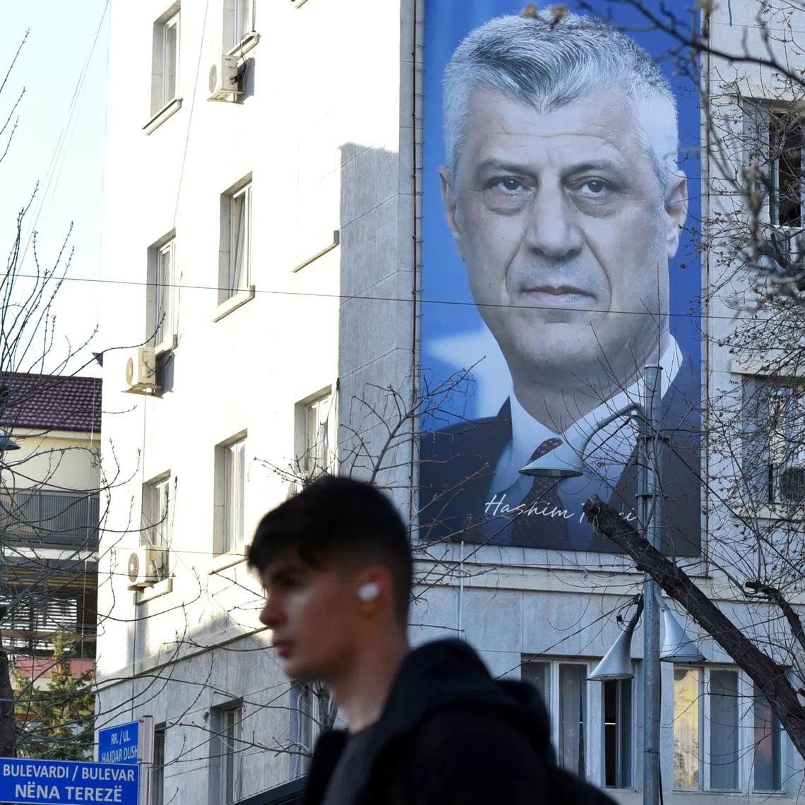 A man walks near a banner displaying former Kosovo President Hashim Thaci, in Pristina, Kosovo, March 30, 2023. REUTERS/Laura Hasani/File Photo