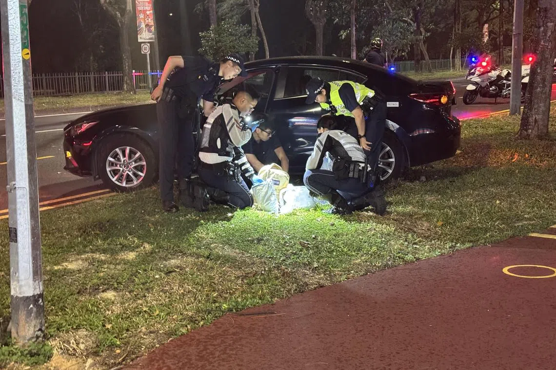 Police searching the belongings of a 28-year old driver after an accident in Hougang Ave 2 on Aug 30.