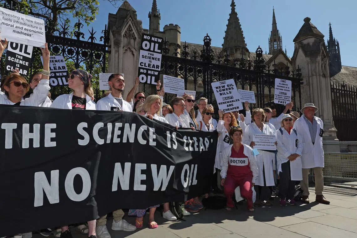 Demonstrators calling for an end to the UK Government awarding new licences for oil and gas production, outside the Houses of Parliament in London on Sept 4.