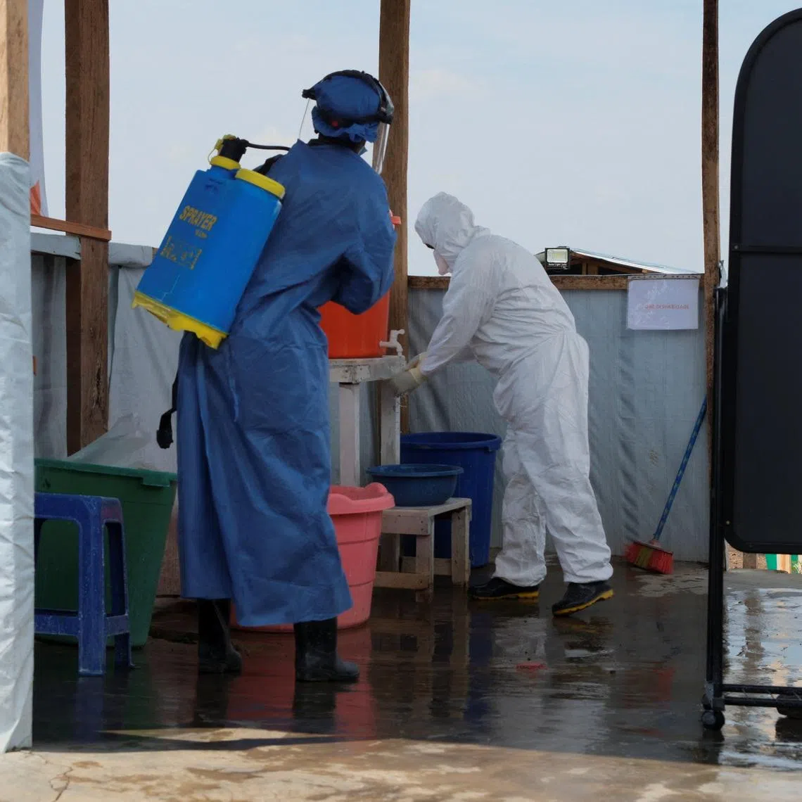 Medical workers dressed in personal protective equipment (PPE) disinfect and wash their hands at an Ebola treatment centre during a ceremony to present recovery certificates to patients at the Rwambara General Reference Hospital in Bunia, eastern Democratic Republic of Congo, June 16, 2026. REUTERS/Gradel Muyisa Mumbere