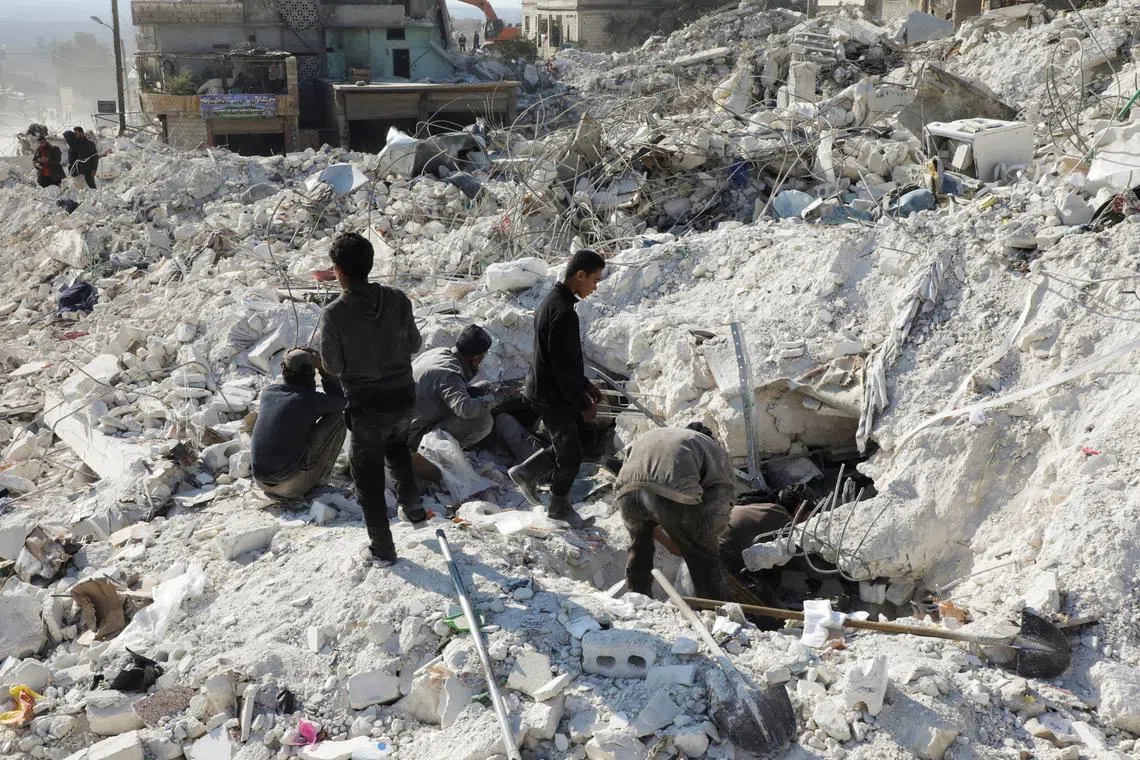 People search under the rubble of damaged buildings in rebel-held town of Harem, Syria, on Feb 13, 2023.