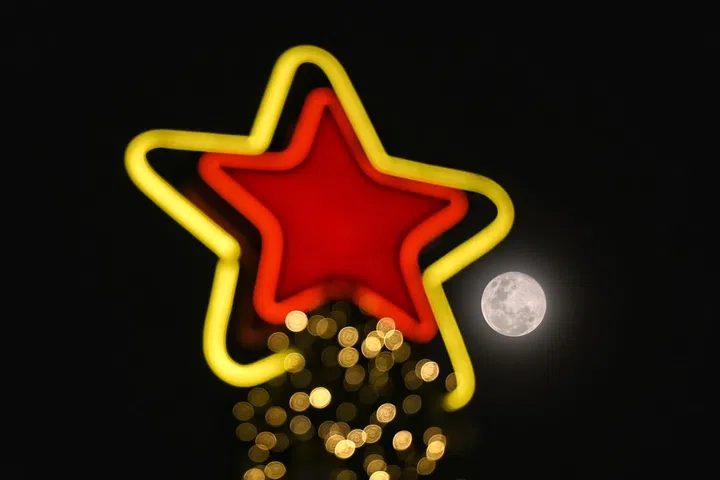 A Lua Fria justaposta a uma árvore de Natal no pomar em 15 de dezembro de 2024.