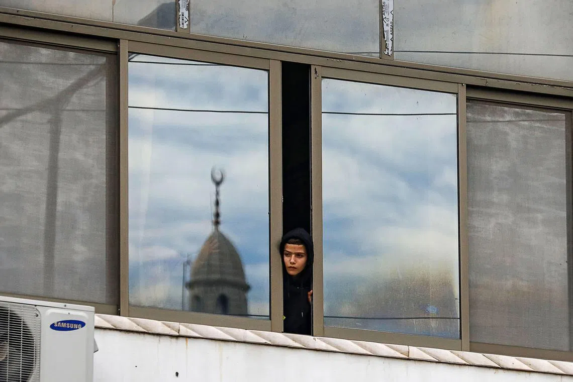 A boy looking out from a window during the funeral of five Palestinians killed during an Israeli raid at the Nur Shams camp for Palestinian refugees near the northern city of Tulkarm in the occupied West Bank on Dec 17, 2023. 