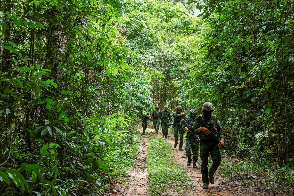 Thai military personnel walk near the forested disputed border between Thailand and Cambodia in the Chong Bok area, following the first incident on July 16 that severed a Thai soldier’s left ankle while he was on patrol, in Ubon Ratchathani province, Thailand, August 27, 2025. REUTERS/Chalinee Thirasupa