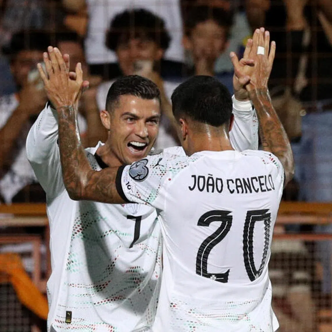 Portugal's Cristiano Ronaldo celebrates scoring their second goal with Joao Cancelo.