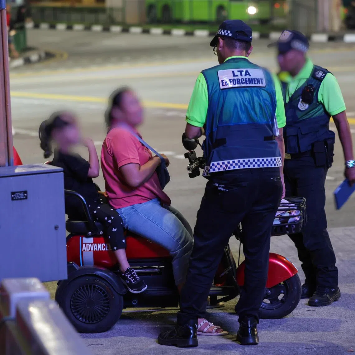 LTA enforcement officers speaking to a PMD user during the enforcement checks in Northpoint City in Yishun on Aug 3.