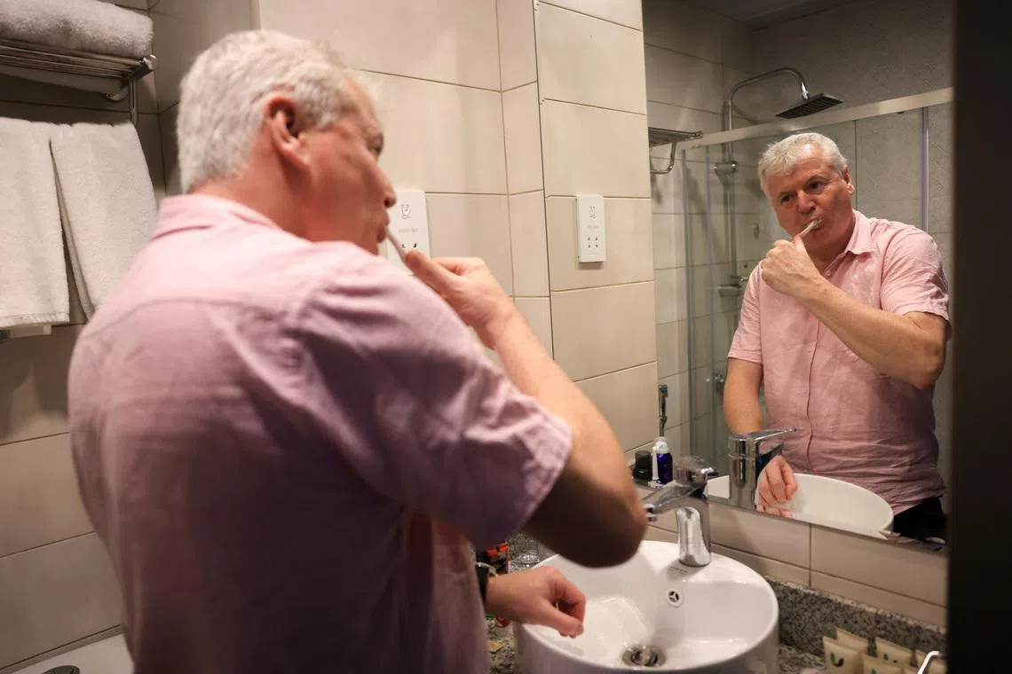 Stranded traveller James Gaskin brushes his teeth in the Vogo Grand Hotel in Dubai on March 2.