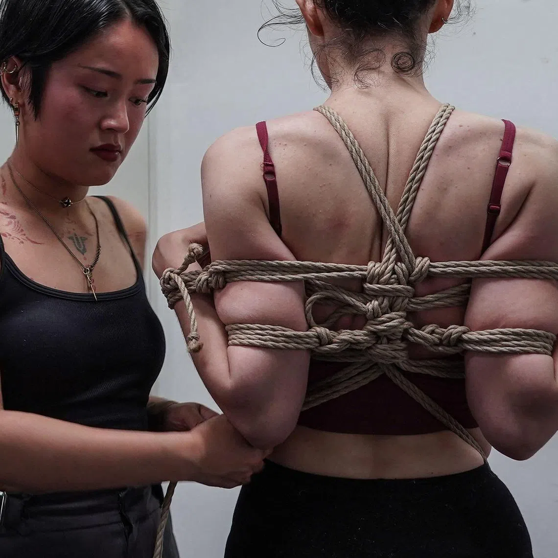 French student Sen (left) applies rope on a model during a certification test to become a “shibari” instructor, at Mr Hajime Kinoko’s studio in May. 