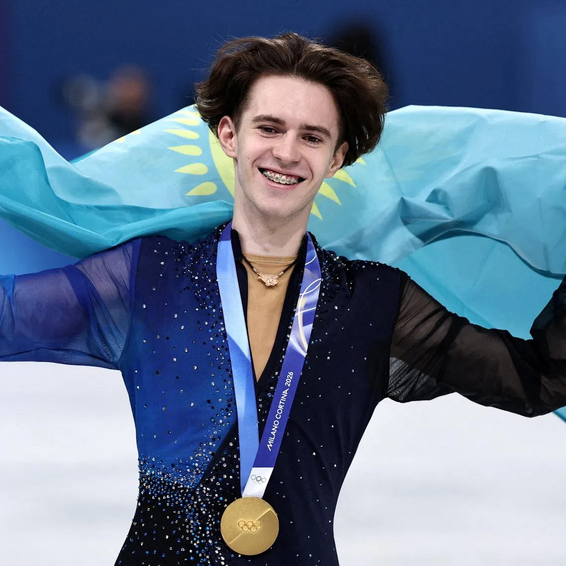 Milano Cortina 2026 Olympics - Figure Skating - Men Single Skating - Victory Ceremony - Milano Ice Skating Arena, Milan, Italy - February 13, 2026. Gold medallist Mikhail Shaidorov of Kazakhstan celebrates with his national flag after winning the Men Single Skating REUTERS/Amanda Perobelli