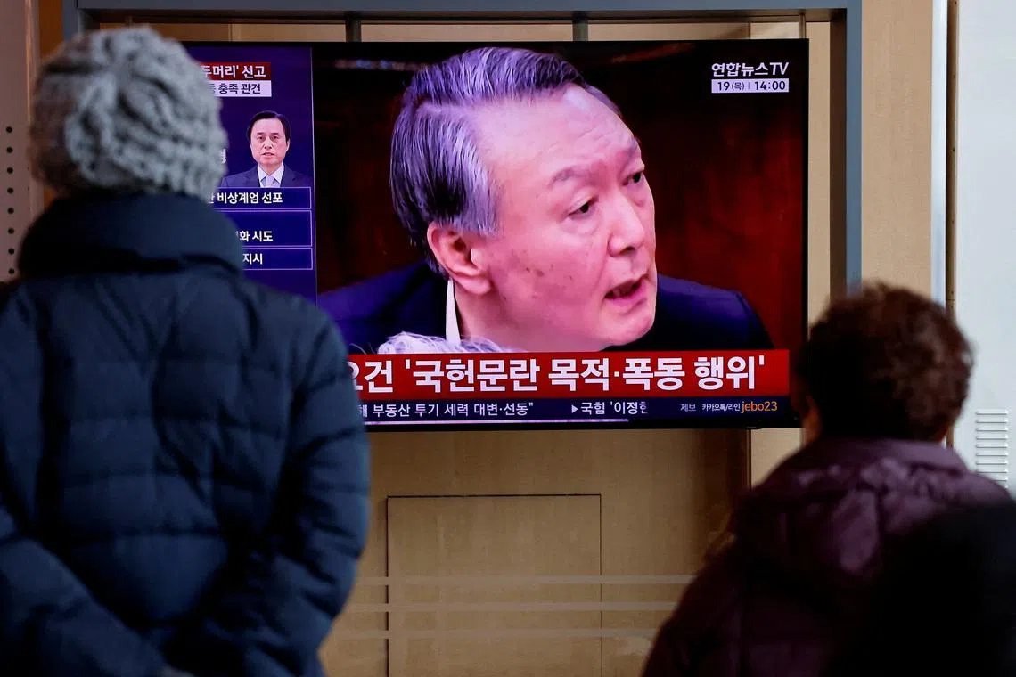 People watch a news report on the sentencing trial of South Korean former president Yoon Suk Yeol's insurrection case, stemming from his short-lived declaration of martial law in December 2024, in Seoul, South Korea, February 19, 2026. REUTERS/Kim Soo-hyeon/File Photo