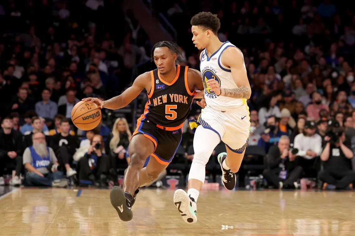 New York Knicks guard Immanuel Quickley brings the ball up court against Golden State Warriors guard Ryan Rollins during the fourth quarter at Madison Square Garden.