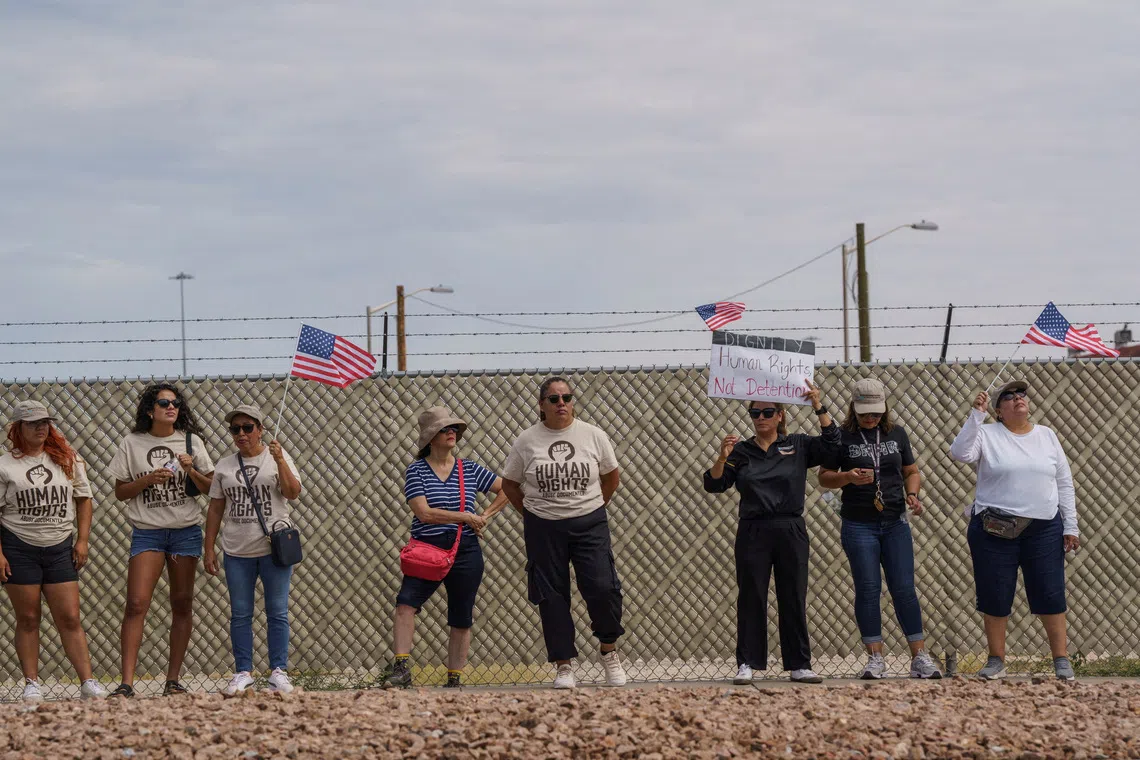 FILE PHOTO: Protesters opposing mass deportations by ICE hold signs during a protest held at the Cassidy Gate at Fort Bliss, the U.S. Army base where a large new ICE detention facility is being built, in El Paso, Texas, U.S., August 17, 2025.  REUTERS/Paul Ratje/File Photo