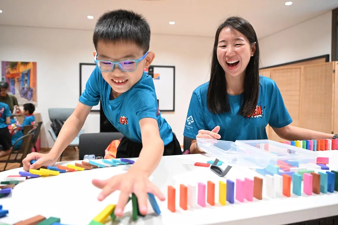 Ms Sabrina Ng, who mentors Primary 4 pupil Nikki Ong as part of the Go the Extra Mile mentoring programme, playing a game of dominoes with the 10-year-old.