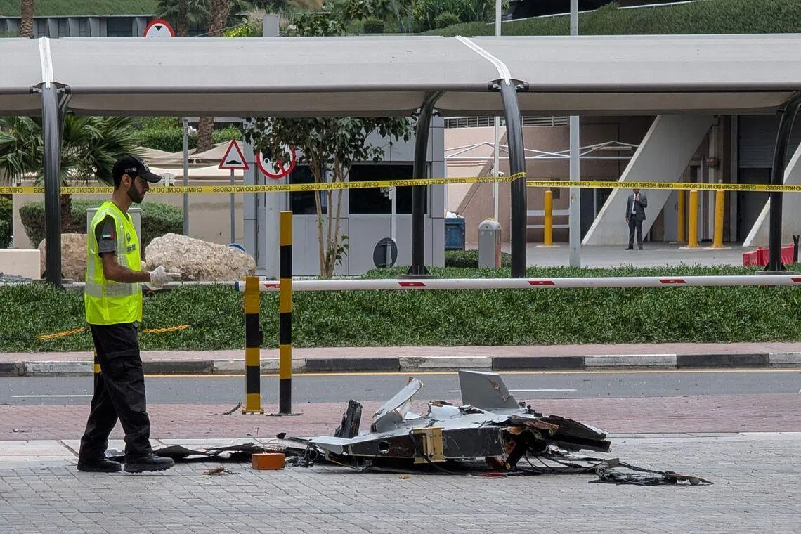 A police officer inspecting the wreckage of a drone in Dubai on March 12.