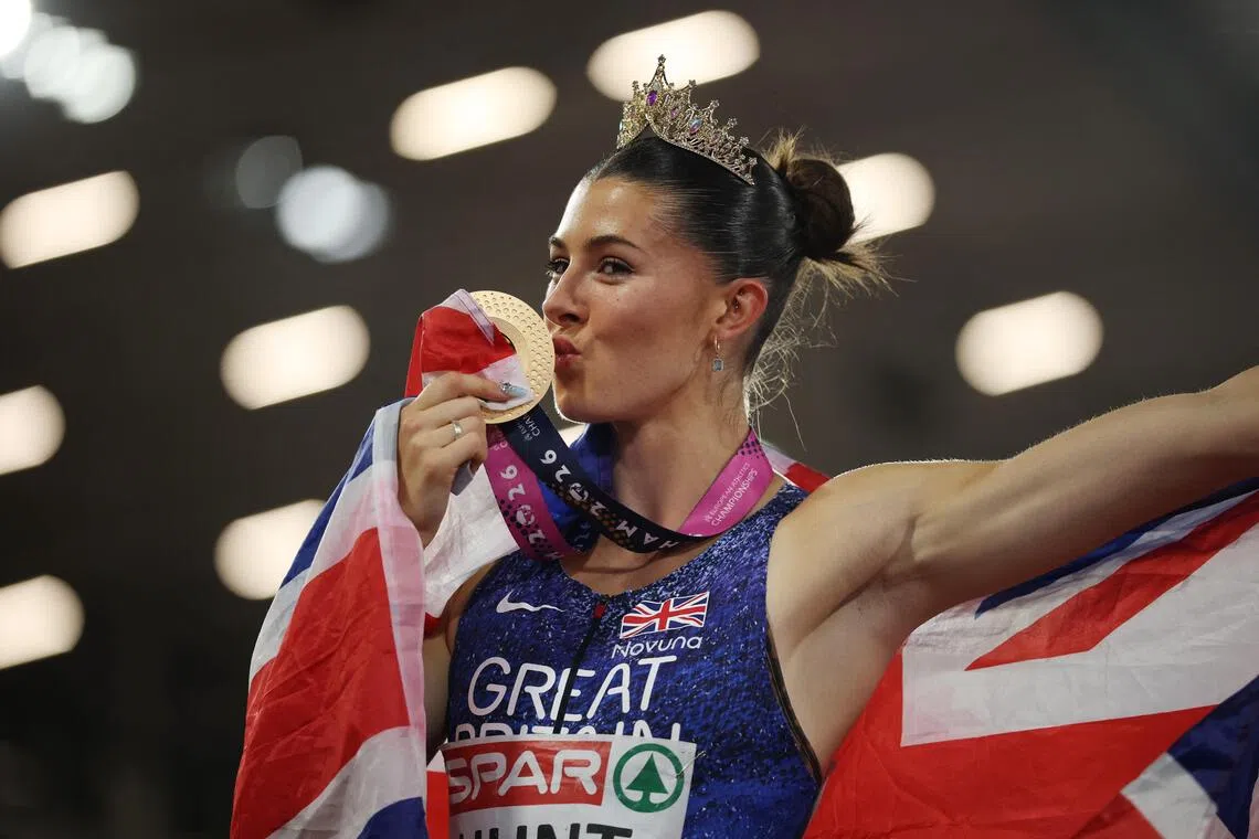 Amy Hunt erupted in joy as she streaked through the finish line, quickly brandishing a Union Jack flag and donning a tiara.