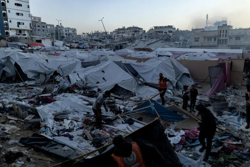 People look over damage after an Israeli airstrike in western Gaza City, on Nov 22.