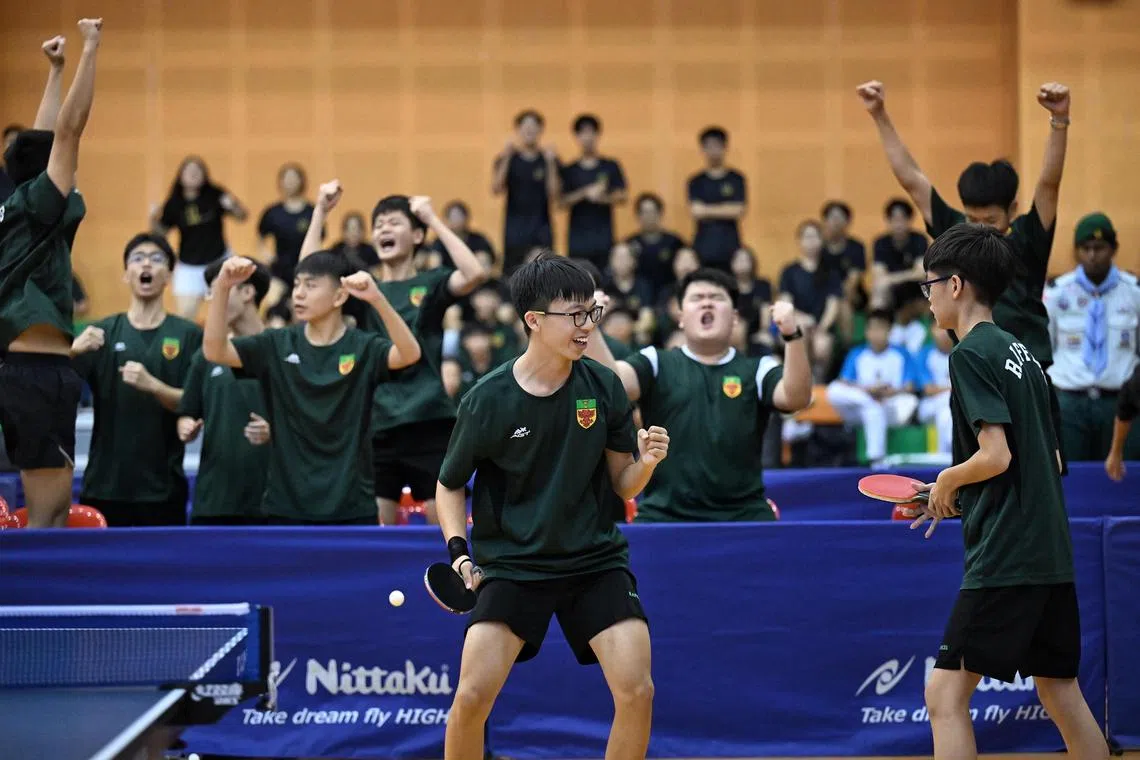 Jaden Koh (left) and Owen Lim from Raffles Institution react after winning the deciding match that crowned them champions in the B Division boys' table tennis final against Hwa Chong Institution on April 9, 2025.