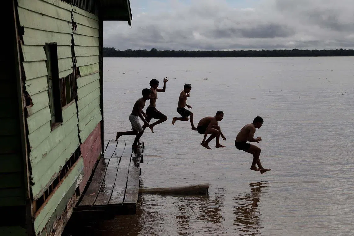 Indigenous children playing in the Solimoes River during the Alvaraes Indigenous Intercultural Games and Dances in Alvaraes, Amazonas state, northern Brazil, on April 16, 2025. 