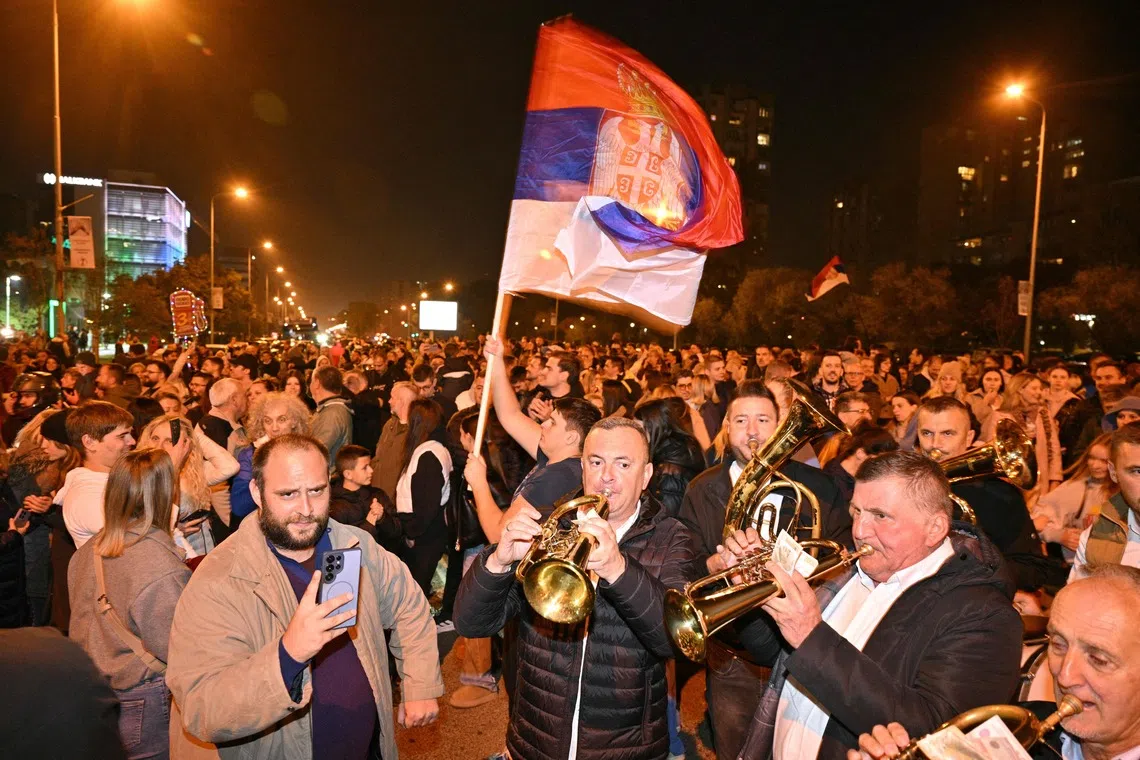 Supporters of the Students’ List wave a giant Serbian flag as they celebrate their victory in the Serbian parliamentary elections on Oct 25.