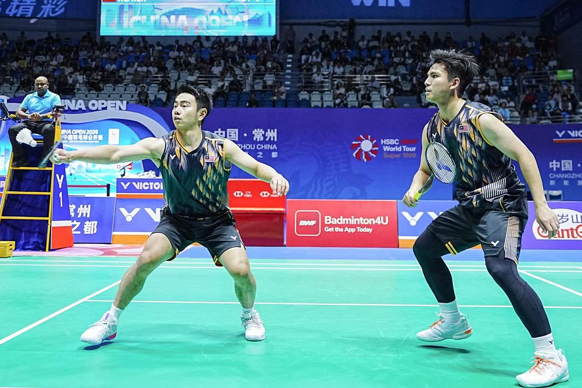 Malaysia's Nur Izzuddin Rumsani (right) and Goh Sze Fei hitting a return against China's He Jiting and Ren Xiangyu during their men's doubles final win at the China Open badminton tournament in Changzhou on Sept 22.