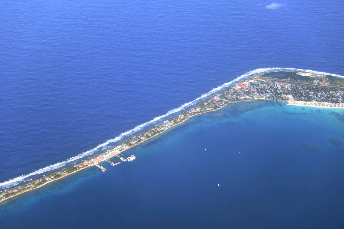 FILE PHOTO: Aerial view of Funafuti, Tuvalu’s most populous island, showing the port and main town of Fongafale, September 6, 2024. Picture taken through plane window. REUTERS/Kirsty Needham/File Photo