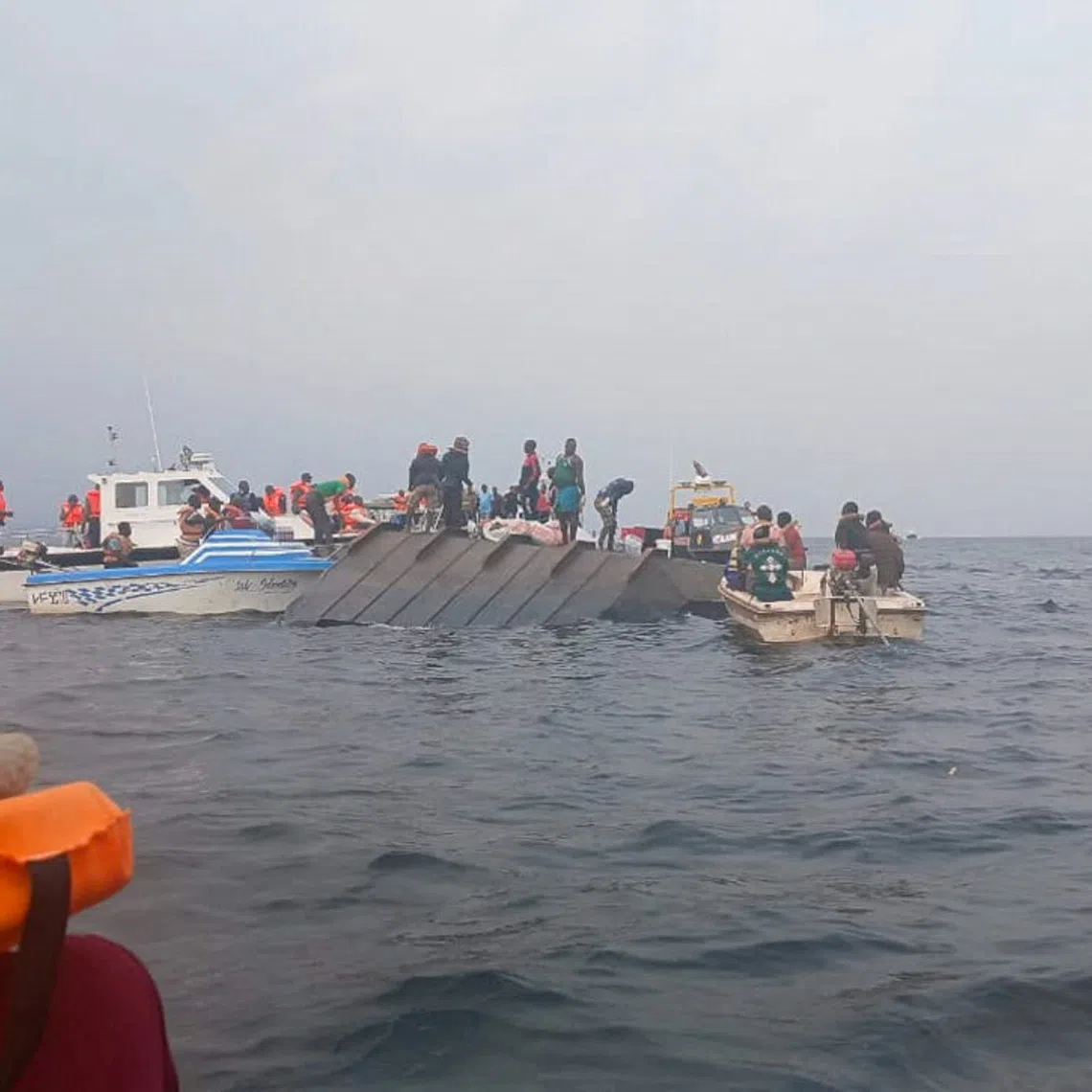 Rescue workers and local boat operators take part in ongoing search and recovery operations near the overturned passenger ferry on Lake Kariba, a day after the vessel capsized, in Kariba, Zimbabwe, August 12, 2026. REUTERS/Admore Mbonda