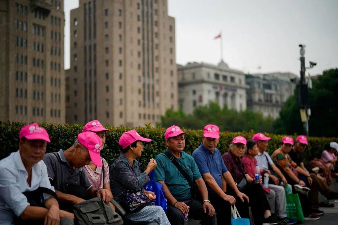 FILE PHOTO: Tourists rest on the Bund ahead of the National Day holiday, in Shanghai, China September 26, 2023. REUTERS/Aly Song/File Photo