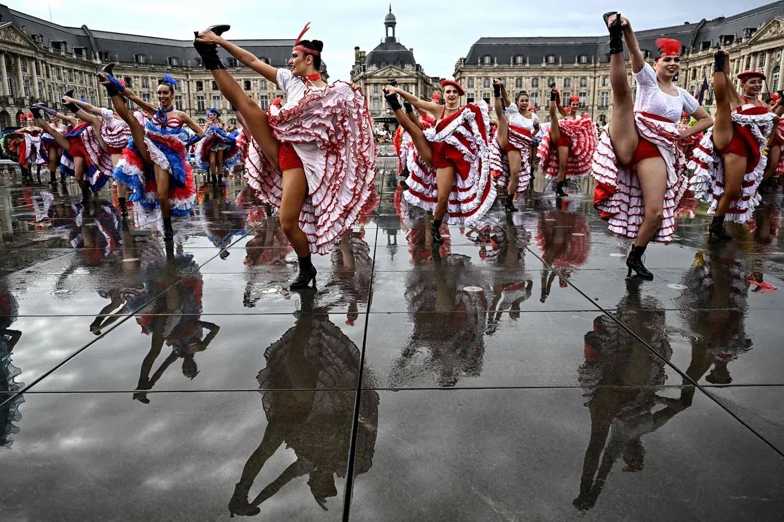 TOPSHOT - Dancers perform during an attempt to break the world record for the highest number of participants in a French Cancan performance, above the Mirroir d'Eau (Water Mirror) reflecting pool in Bordeaux, south-western France on September 30, 2026. (Photo by Christophe ARCHAMBAULT / AFP)