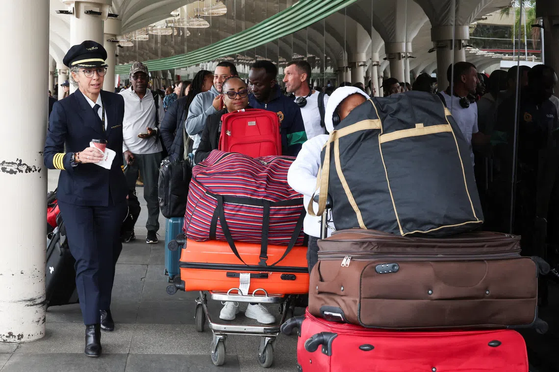 An airline official walks as travellers queue and wait to be processed to travel after Kenya aviation workers ended their strike that disrupted flights at the Jomo Kenyatta International Airport (JKIA) in Nairobi, Kenya, September 1, 2026. REUTERS/Monicah Mwangi