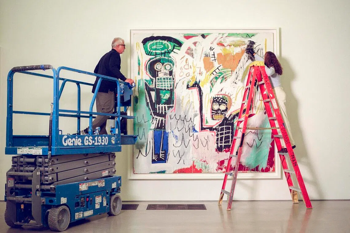 Basquiat’s Untitled (Baptismal), painted in 1982, receives a final dusting before the public opening of the exhibition, Basquiat: Figures, Signs, Symbols, at the Perez Art Museum Miami in June. Ten of Ken Griffin’s Basquiats are on loan to PAMM.