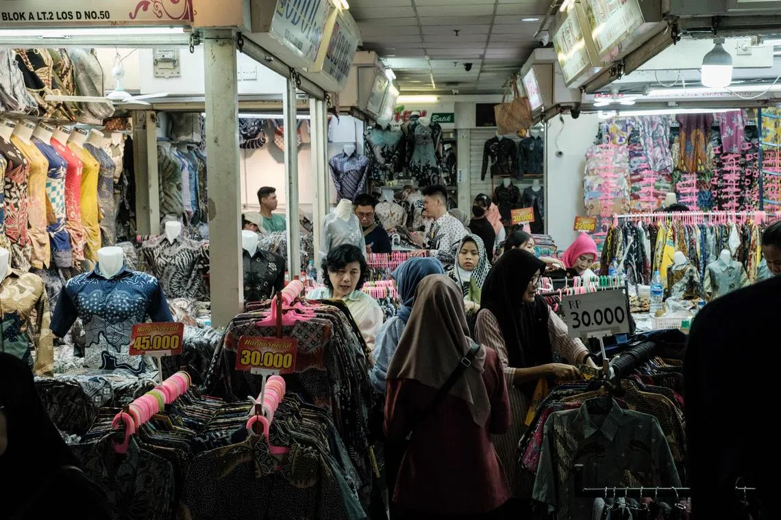 People look for Indonesia's traditional "batik" cloth at Tanah Abang Market, Southeast Asia's largest wholesale shopping center for garment and textile, in Jakarta on September 28, 2023. (Photo by Yasuyoshi CHIBA / AFP)