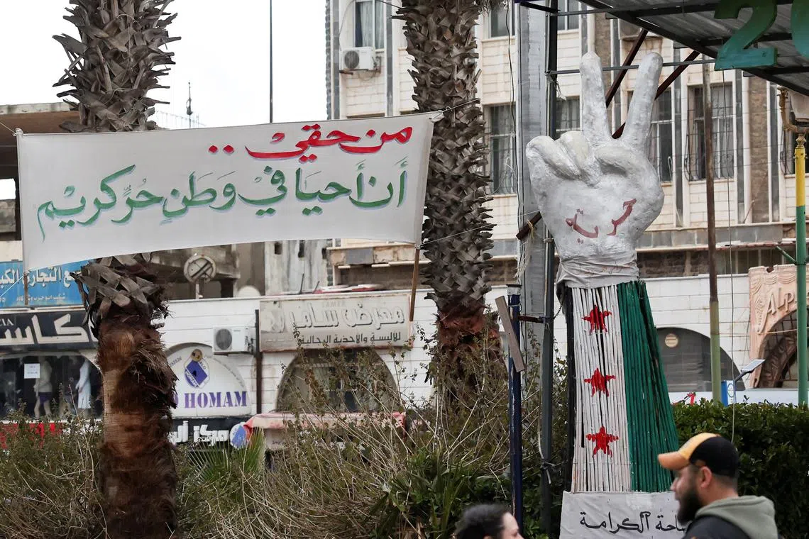 A banner reading \"I have the right to live in a free and dignified homeland\" is put up at Al-Karama Square in Sweida, Syria February 20, 2025. REUTERS/Yamam Al Shaar