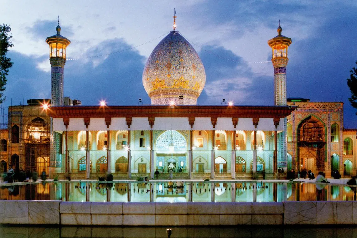 Attackers in a car shot at pilgrims and staff at the entrance to the shrine of Shah Cheragh, according to witnesses.