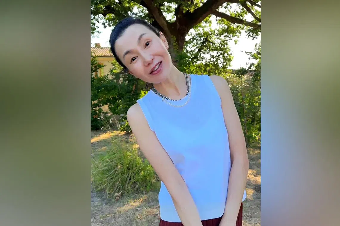 Maggie Cheung is seen strolling outdoors, sporting a simple blue tank top and miminal make-up in her debut video.