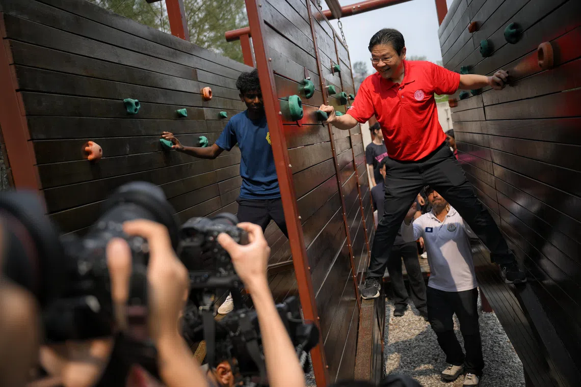 Guest-of-Honour Prime Minister Lawrence Wong (right) manoeuvres an obstacle with students at OBS Coney Campus on Sept 11, 2026.