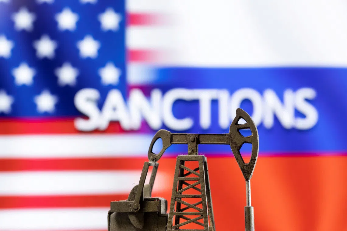 FILE PHOTO: A model of a pump jack is seen in front of the displayed word \"Sanctions\",  U.S. and Russia flag colours in this illustration taken March 8, 2022. REUTERS/Dado Ruvic/Illustration/File Photo