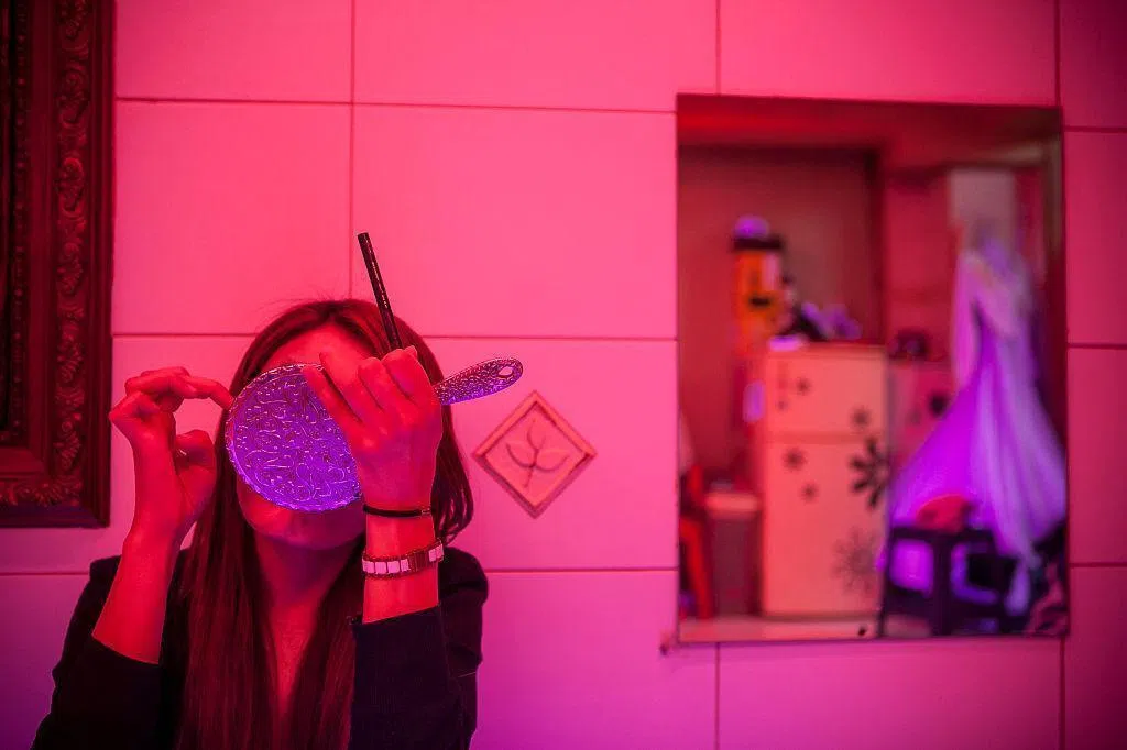 A sex worker applies a makeup in Miari red light district in Seoul, South Korea.