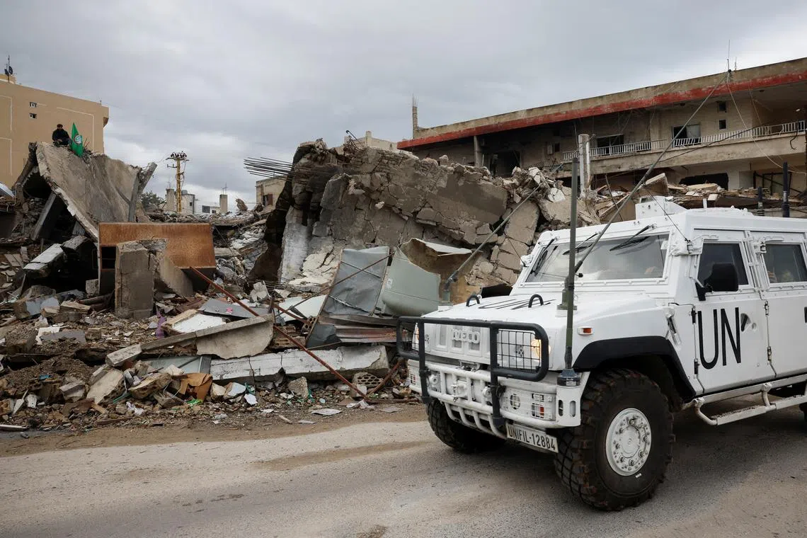 A U.N vehicle drives past destroyed buildings, after a ceasefire between Israel and Iran-backed group Hezbollah took effect at 0200 GMT on Wednesday after U.S. President Joe Biden said both sides accepted an agreement brokered by the United States and France, in Tyre, Lebanon, November 27, 2024. REUTERS/Adnan Abidi