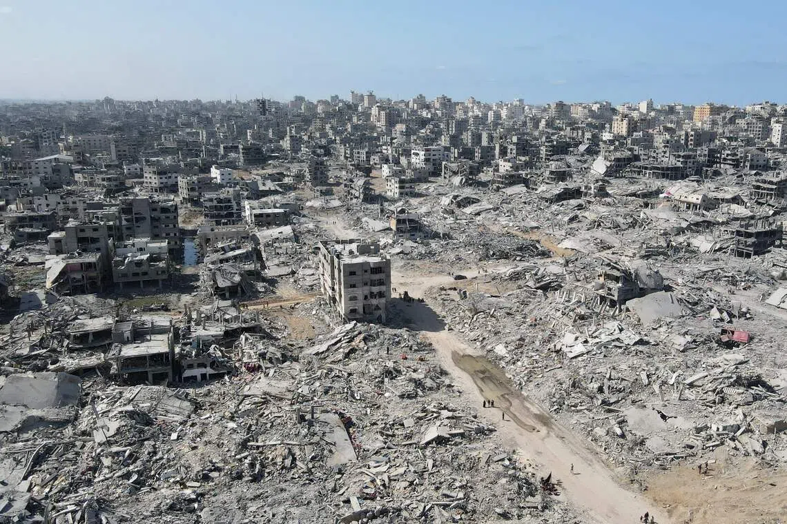 Aerial view of displaced Palestinians walking amid the destruction in Gaza City in the northern Gaza Strip on Oct 11, 2025, a day after a ceasefire took effect. 