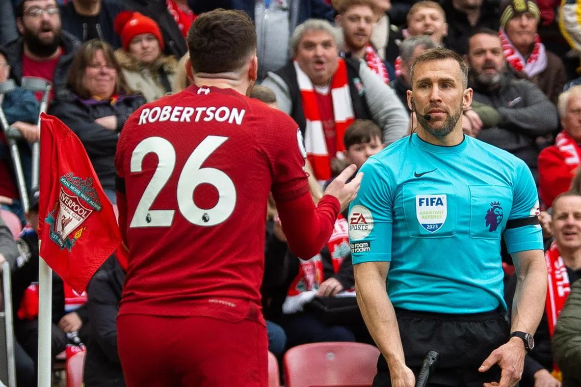 Liverpool's Andy Robertson (left) speaks to assistant referee Constantine Hatzidakis during the match against Arsenal on Sunday.