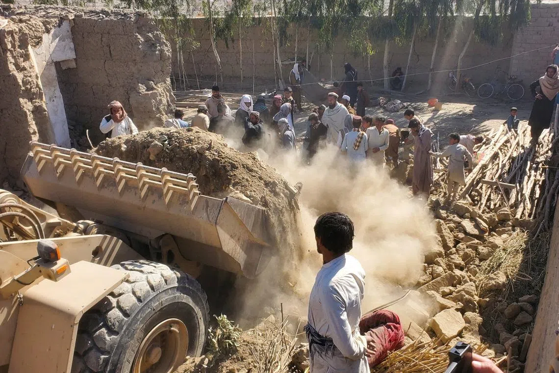 FILE PHOTO: Residents gather as machinery clears the debris of a damaged house, following the Pakistani air strikes, in Nangarhar, Afghanistan, February 22, 2026. REUTERS/Stringer/File Photo