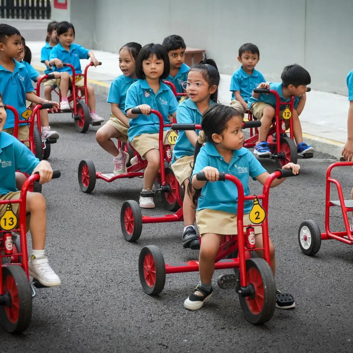 绿洲小学内的教育部幼儿园学生骑着儿童脚踏车游玩。