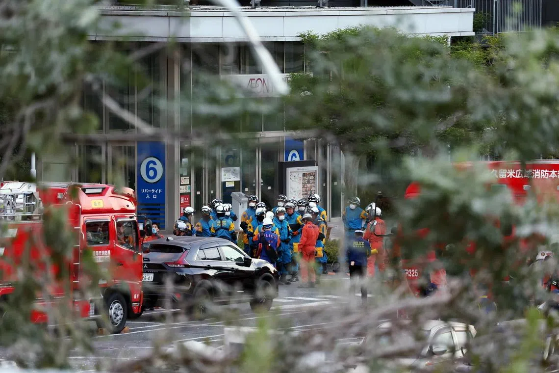 Police officers and firefighters gather outside AEON Mall Kumamoto, on July 29.